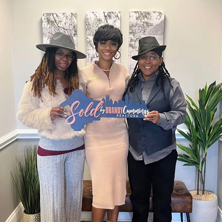 Tawanda and Nicola Bell with Brandy, holding a ‘Sold by Brandy Cummings’ sign